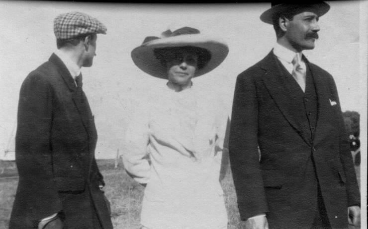 Two men and a woman on a field.  The man in the plaid cap may be Coffyn.