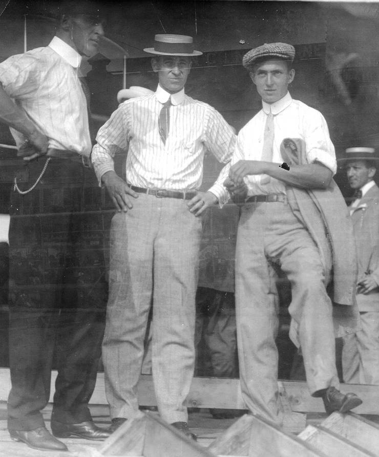 Frank Coffyn (left) and Walter Brookins (right) with Roy Knabenshue(center) outside boardwalk shed for Wright transitional aircraft.