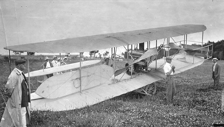 Frank Coffyn standing behind Wright transitional aircraft packed for transportation.
