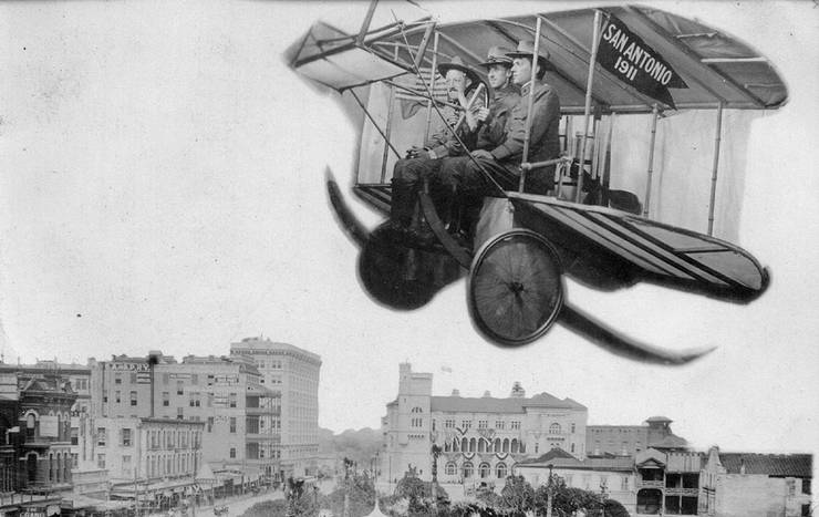 Three unidentified military officers posing in a staged flying machine. 