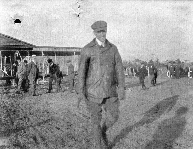 Frank Coffyn walking in front of a Wright Model B.
