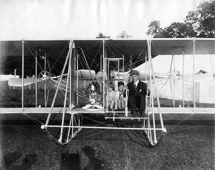 Kingsland Coffyn, an unidentified child, and Frank Coffyn posing in a Wright aircraft.